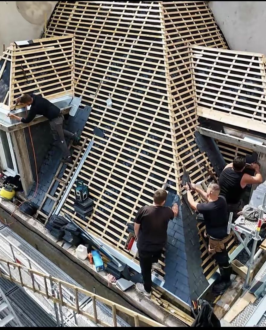 Compagnons Lamberty assemblant une charpente neuve en bois